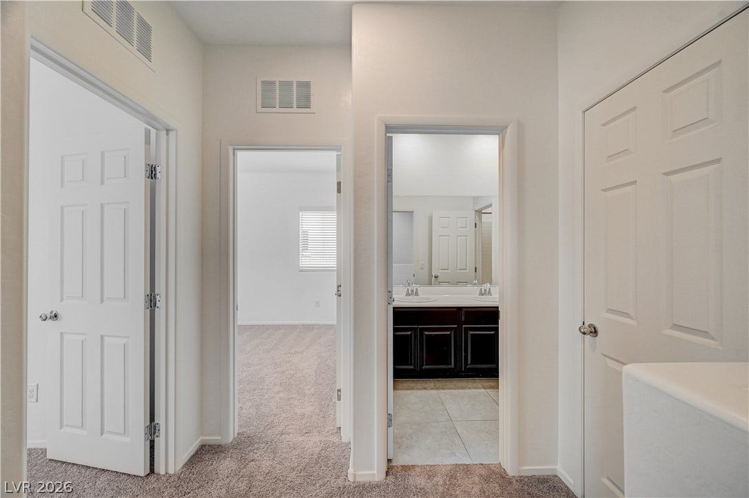 2455 Sunflower Days Avenue, #1056, North Las Vegas, NV 89031 An inviting hallway connects comfortable bedrooms with a central shared bathroom.