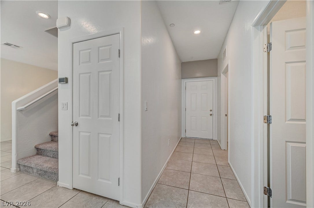 2455 Sunflower Days Avenue, #1056, North Las Vegas, NV 89031 A tiled hallway connects the main living spaces with a carpeted staircase leading upstairs.