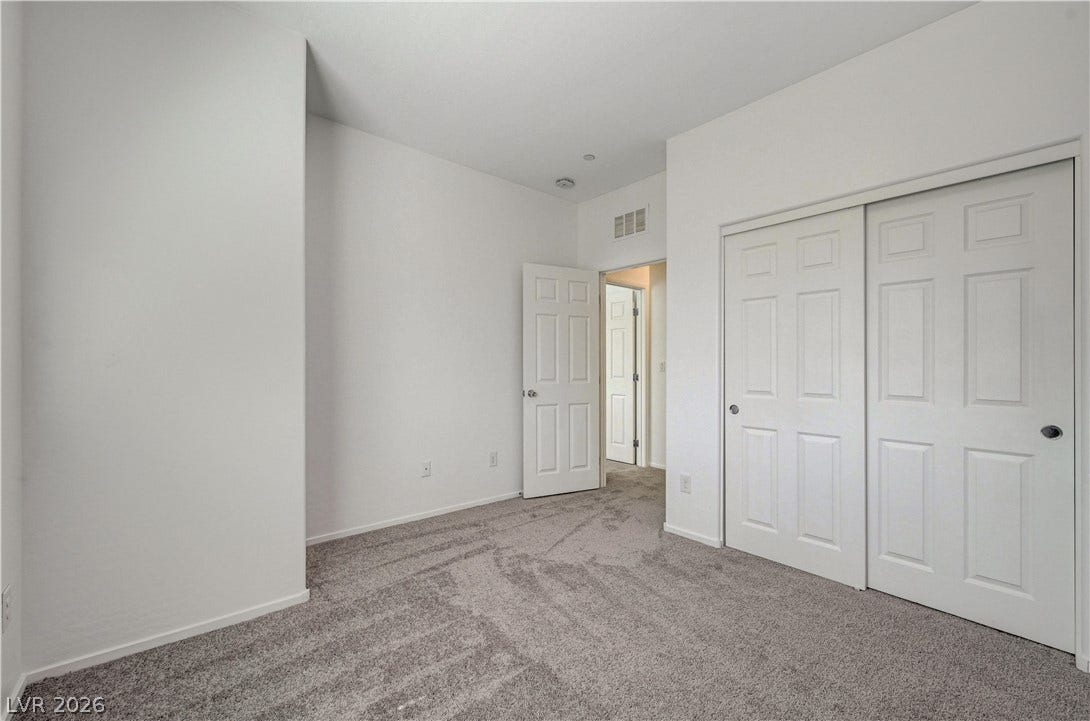2455 Sunflower Days Avenue, #1056, North Las Vegas, NV 89031 Plush carpeting and crisp white walls define this comfortable secondary bedroom.