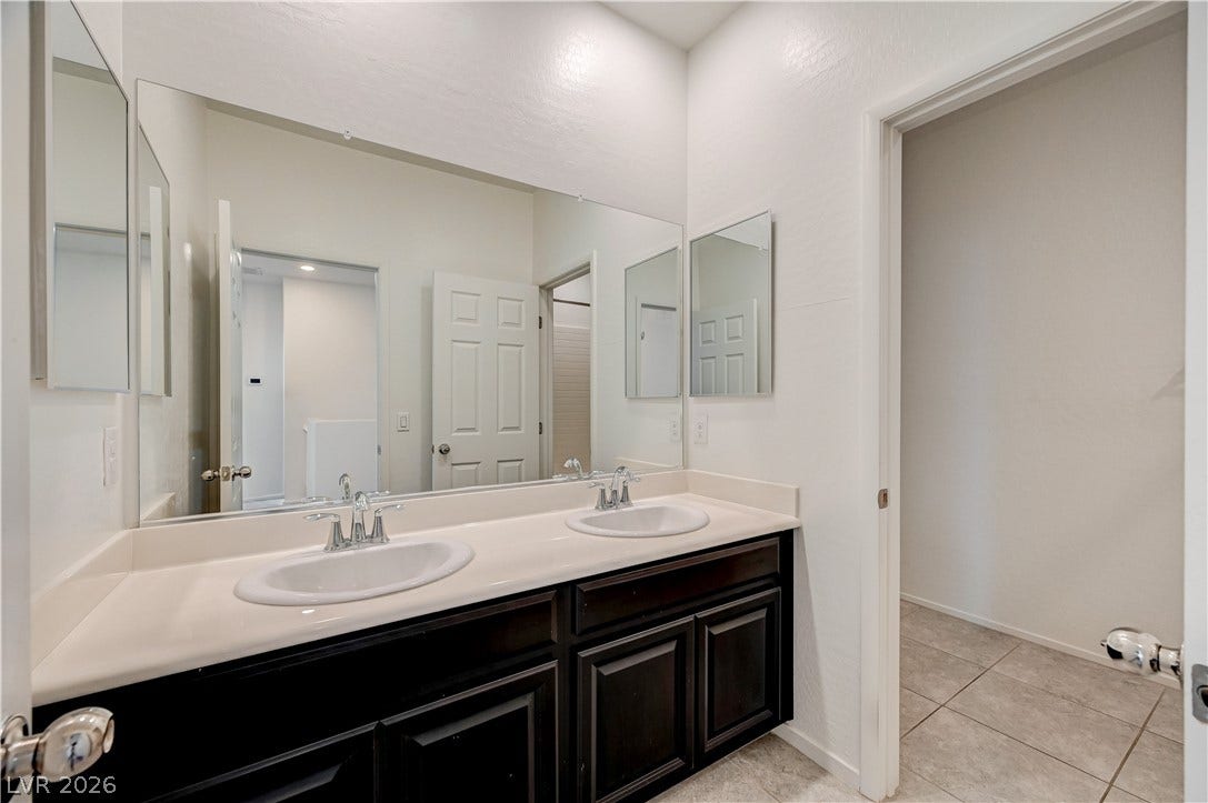 2455 Sunflower Days Avenue, #1056, North Las Vegas, NV 89031 Clean lines and a spacious dual vanity define this functional bathroom.