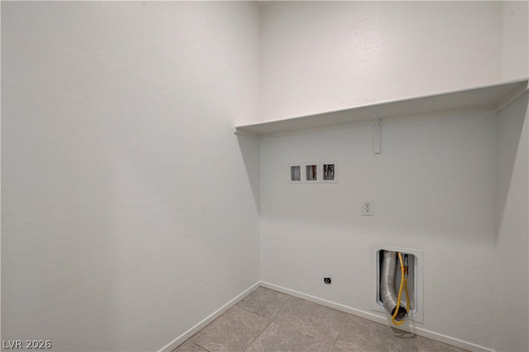 2455 Sunflower Days Avenue, #1056, North Las Vegas, NV 89031 Tiled flooring and a built-in storage shelf define this functional utility space.