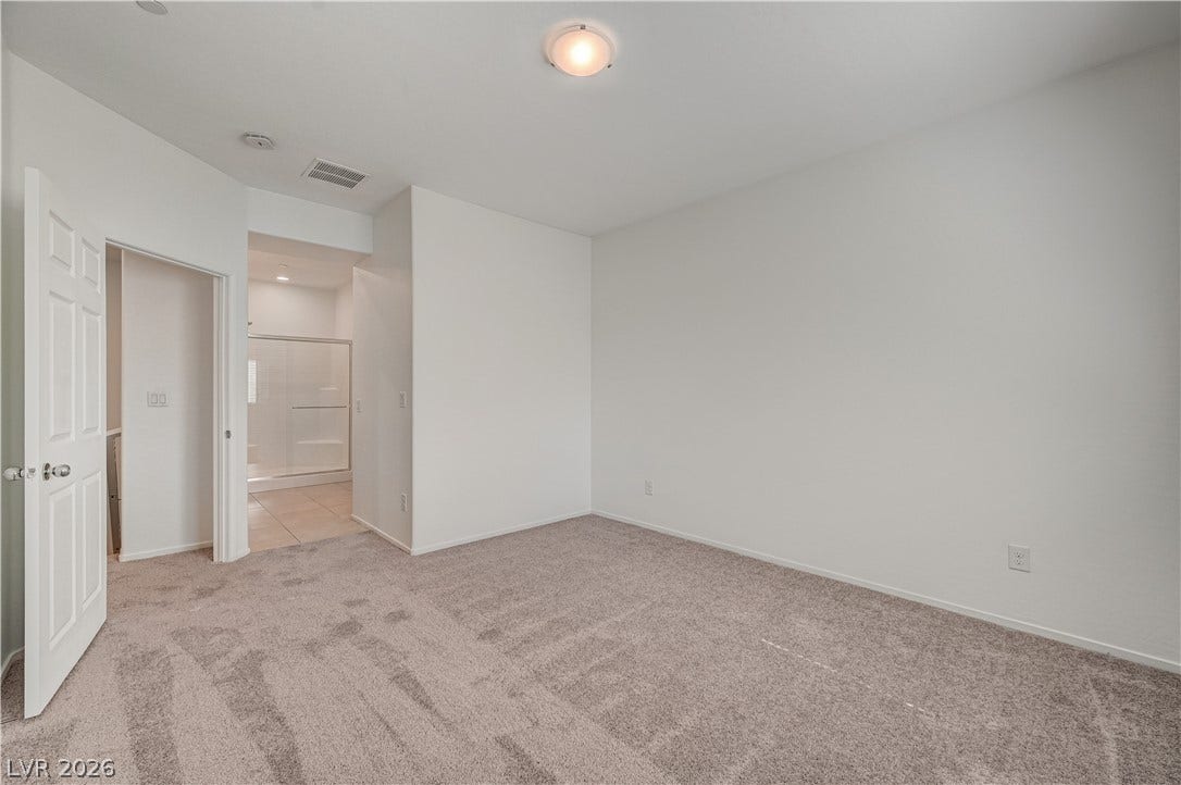 2455 Sunflower Days Avenue, #1056, North Las Vegas, NV 89031 Plush carpeting and crisp neutral walls define this versatile bedroom with an attached bathroom.