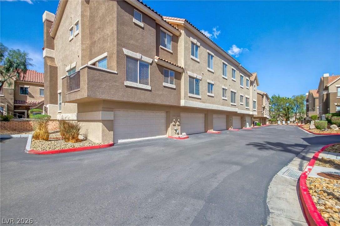 2752 Fountain Vista Lane, Henderson, NV 89074 Multi-level townhouse units feature built-in ground floor garages alongside paved access roads.