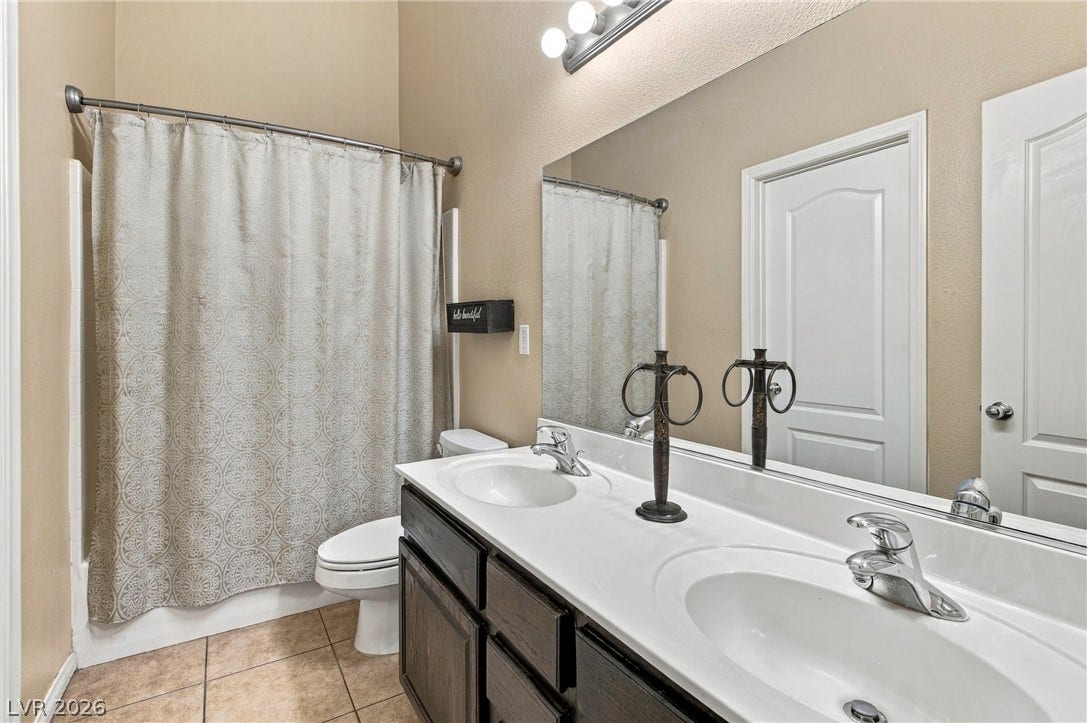 2752 Fountain Vista Lane, Henderson, NV 89074 Tile flooring and a spacious double vanity with a broad mirror highlight this bathroom.