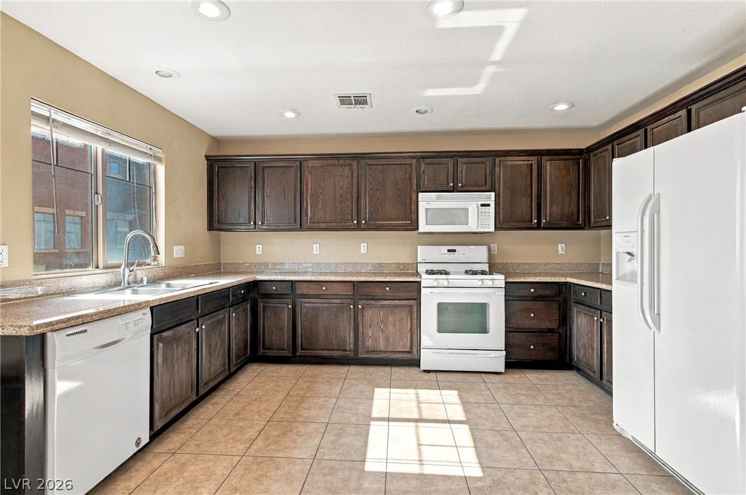 2752 Fountain Vista Lane, Henderson, NV 89074 Rich dark wood cabinetry pairs beautifully with expansive countertops and neutral tile flooring.