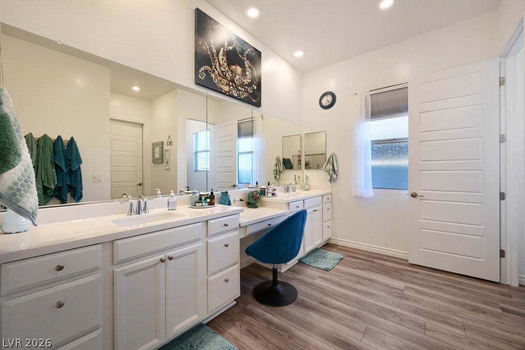 752 Dorsey Falls Street, Henderson, NV 89011 Wood-look flooring and dual vanities highlight this spacious bathroom layout.