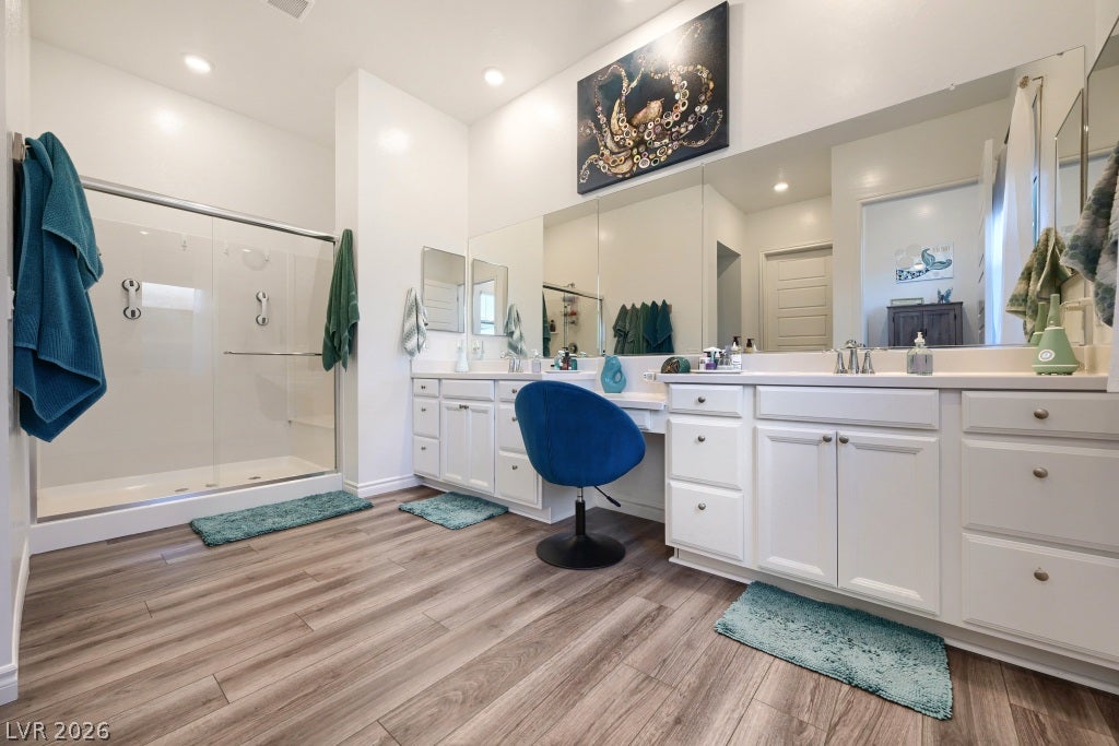 752 Dorsey Falls Street, Henderson, NV 89011 A spacious vanity area anchors this modern bathroom with a walk-in shower and wood-look flooring.