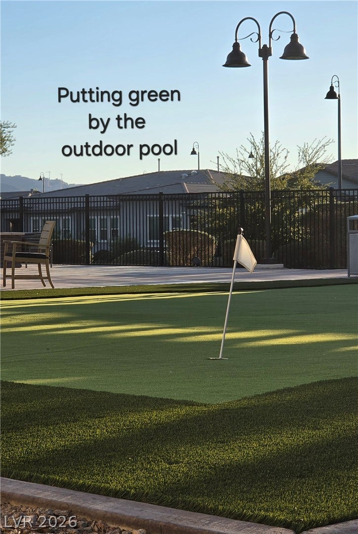 752 Dorsey Falls Street, Henderson, NV 89011 An outdoor putting green sits adjacent to the paved pool deck under clear blue skies.