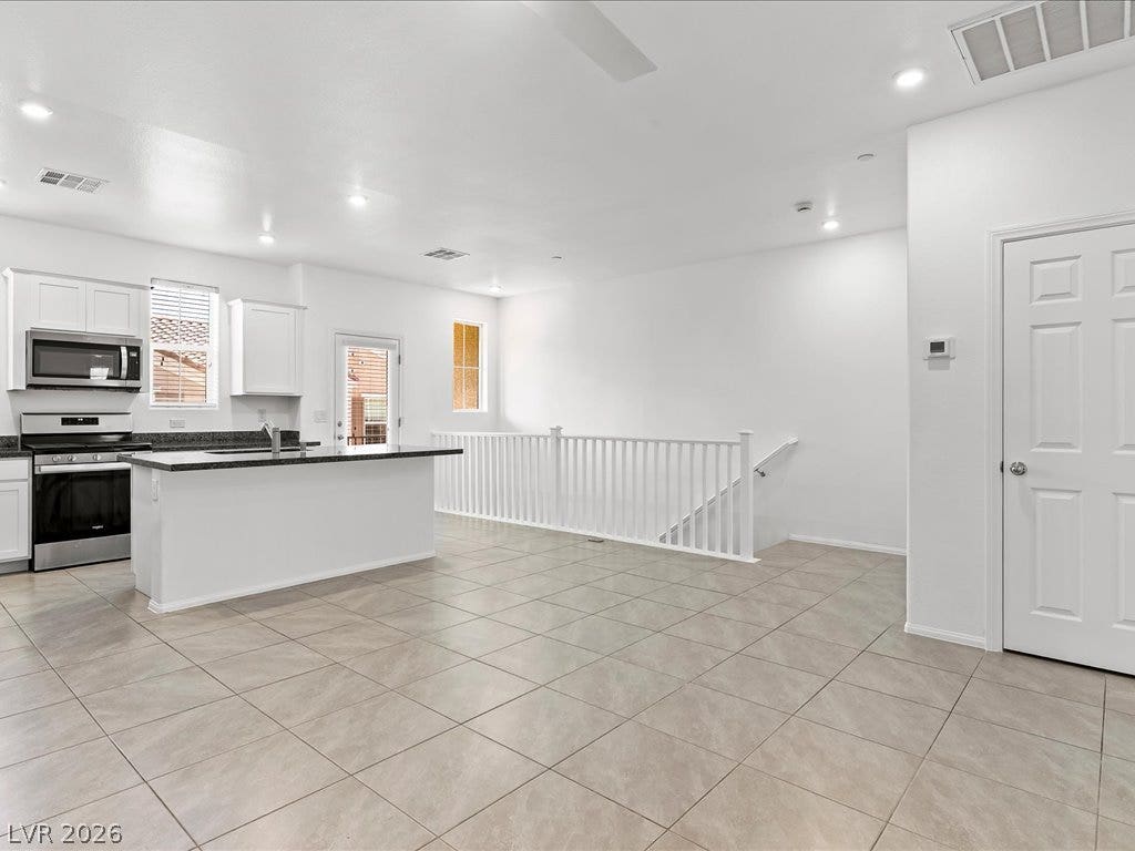 671 Foam Flower Lane, Henderson, NV 89015 Tiled floors and recessed lighting enhance this airy layout flowing past the central kitchen island.