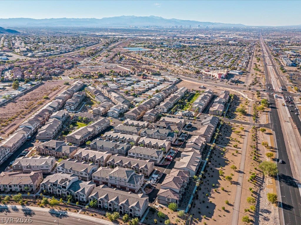 671 Foam Flower Lane, Henderson, NV 89015 An aerial perspective reveals the neighborhood layout set against distant mountain ridges.