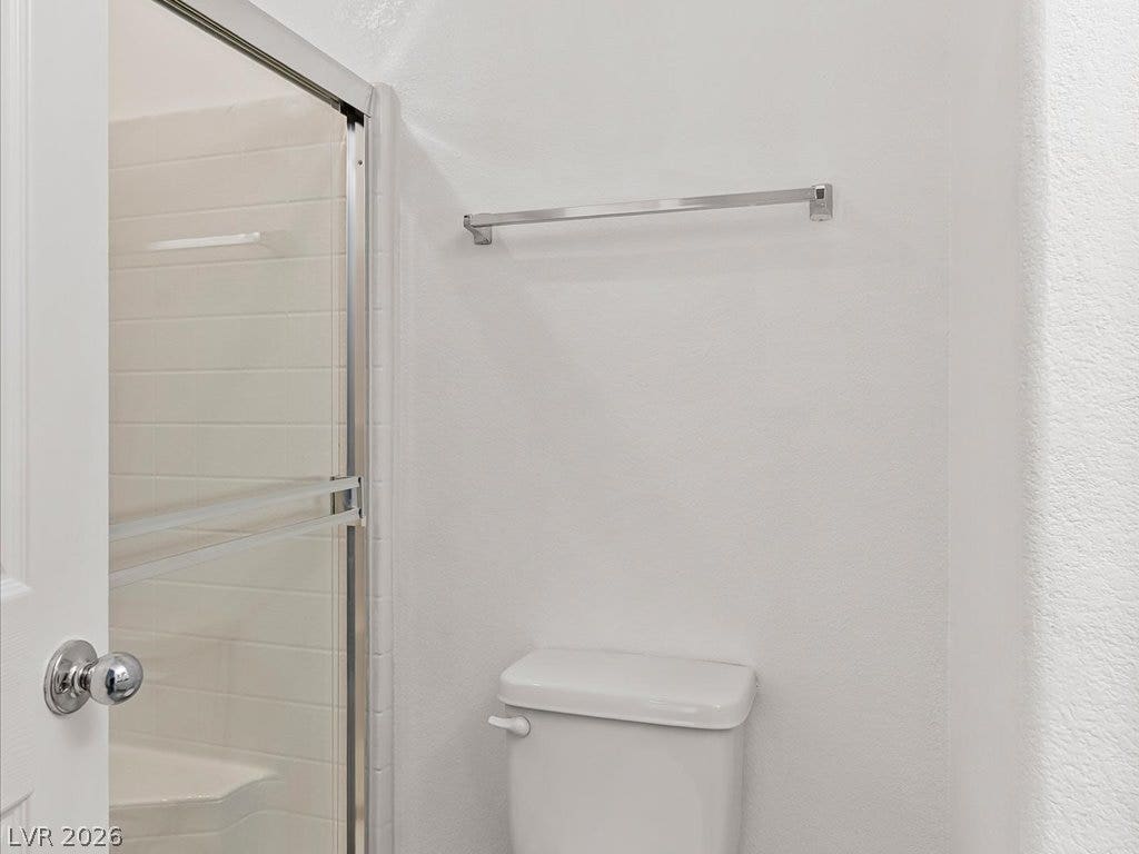 671 Foam Flower Lane, Henderson, NV 89015 A glass-enclosed walk-in shower features neutral tile surround in this functional bathroom.