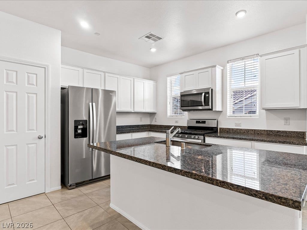 671 Foam Flower Lane, Henderson, NV 89015 Polished stone countertops pair with clean cabinetry in this well-appointed cooking space.