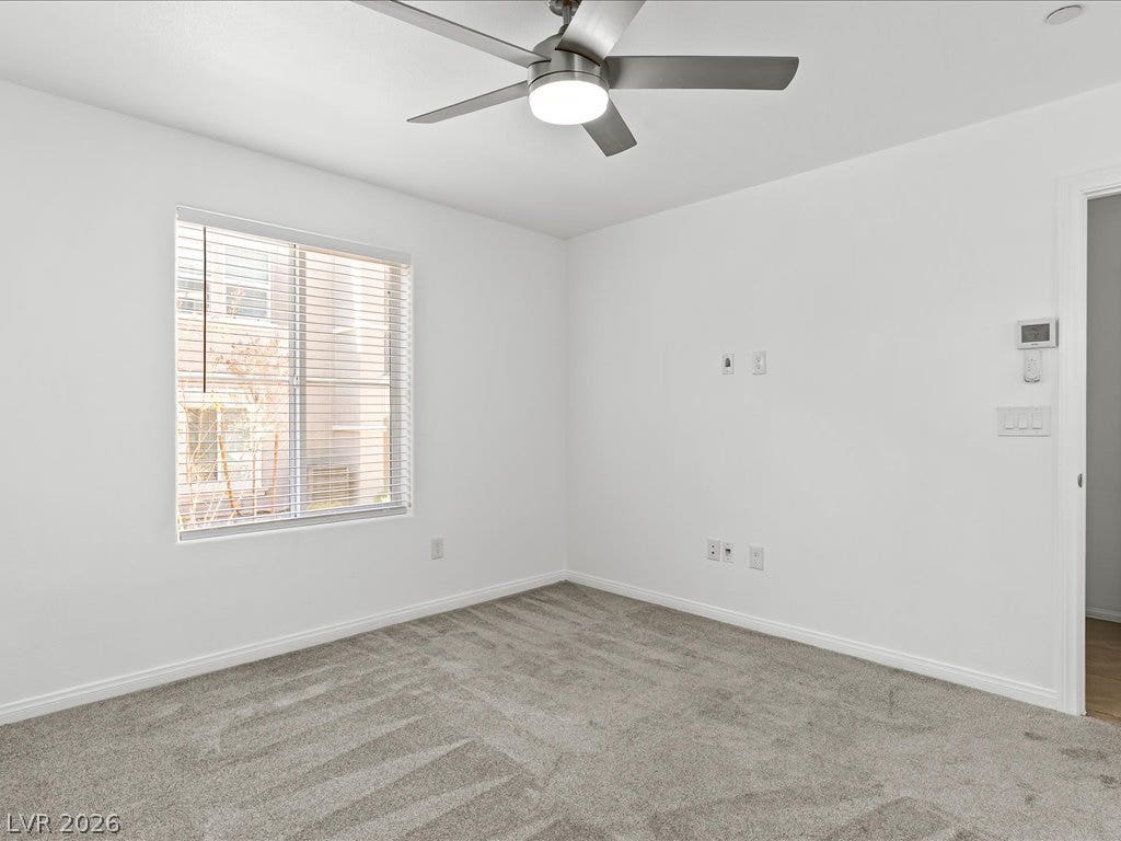 671 Foam Flower Lane, Henderson, NV 89015 Down stairs Primary Bedroom with Soft carpeting pairs with crisp walls under natural light filtering through a large window.