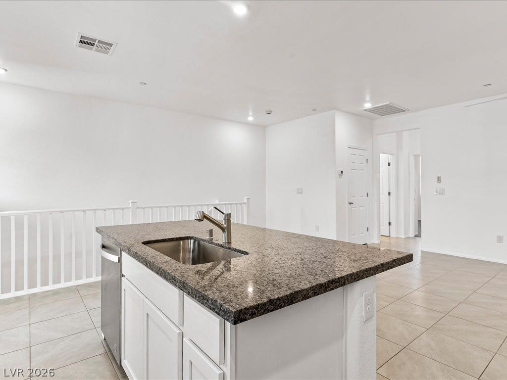 671 Foam Flower Lane, Henderson, NV 89015 Polished granite countertops and clean tile flooring define this modern, open-concept kitchen space.