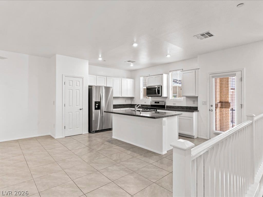 671 Foam Flower Lane, Henderson, NV 89015 Tiled flooring and solid countertops anchor this contemporary culinary workspace.
