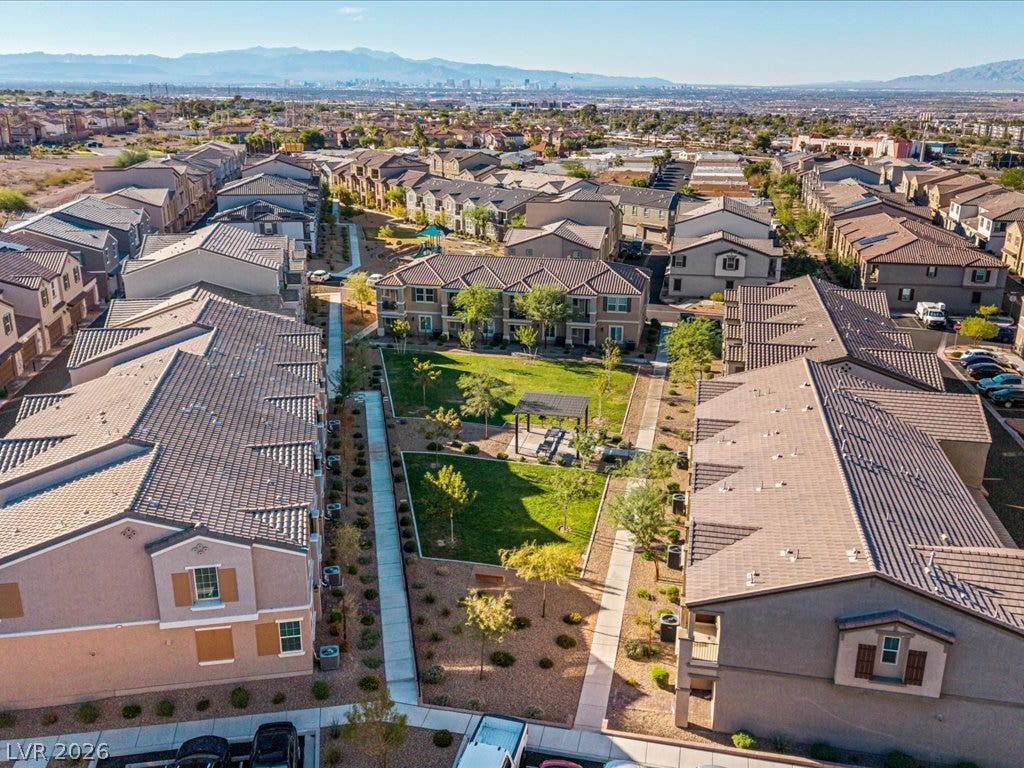 671 Foam Flower Lane, Henderson, NV 89015 Distant mountains frame this residential neighborhood featuring tile-roofed buildings and landscaped pathways.