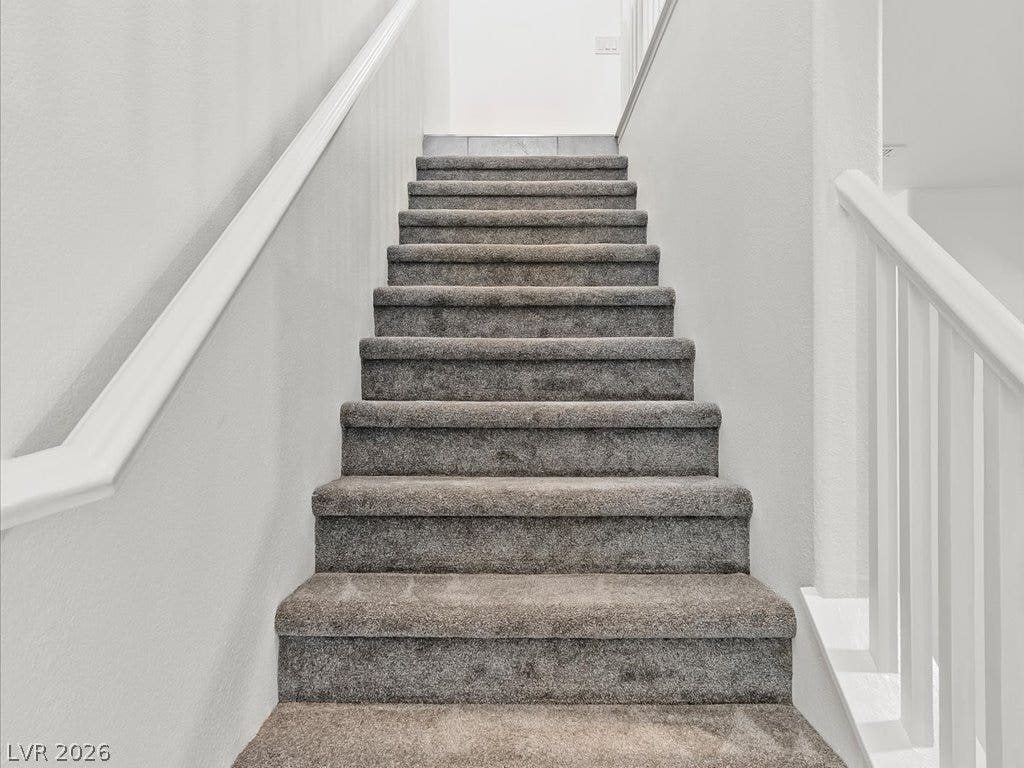 671 Foam Flower Lane, Henderson, NV 89015 Plush carpeted stairs ascend between clean neutral walls and classic white handrails.