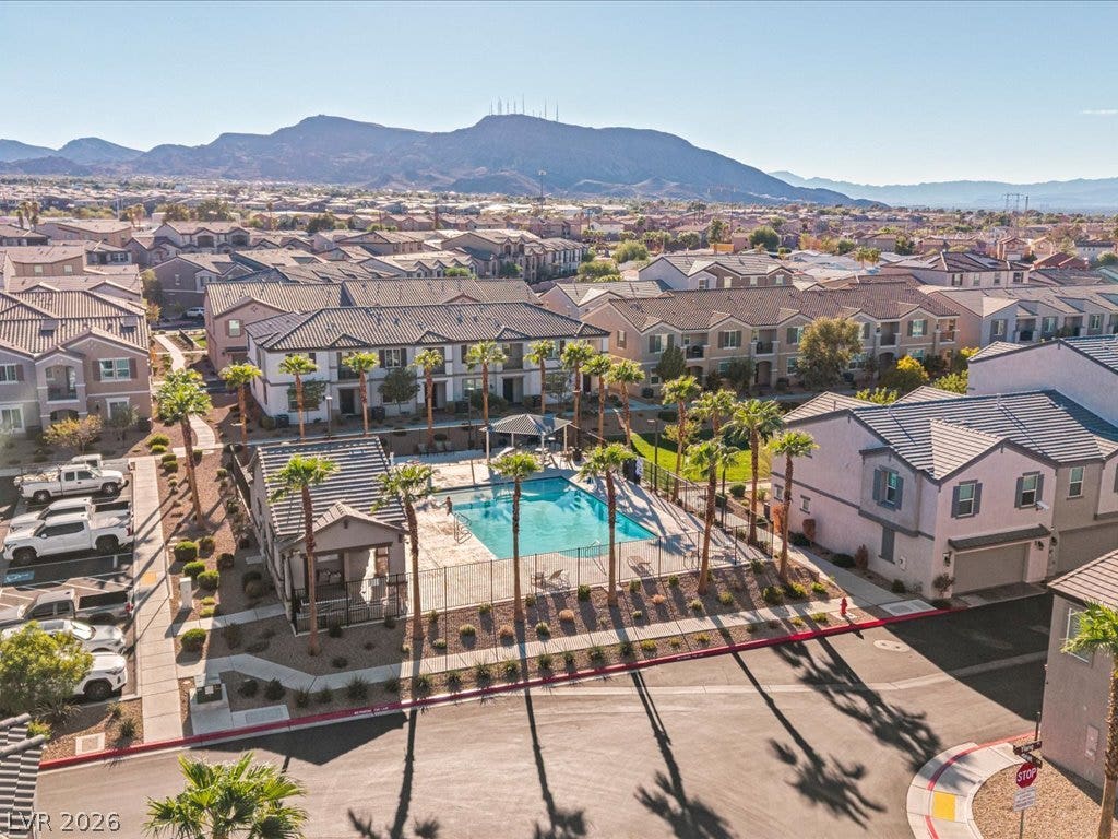 671 Foam Flower Lane, Henderson, NV 89015 A sparkling community pool sits framed by palm trees against a dramatic mountain backdrop.