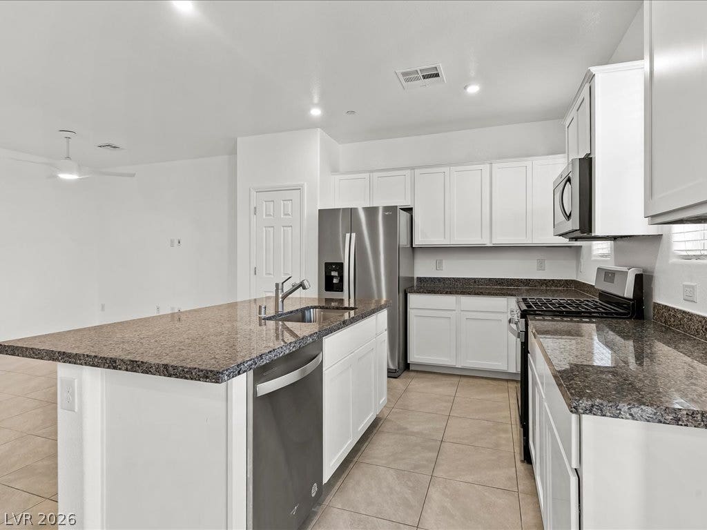 671 Foam Flower Lane, Henderson, NV 89015 Gleaming stone countertops and stainless steel appliances anchor this modern culinary workspace.