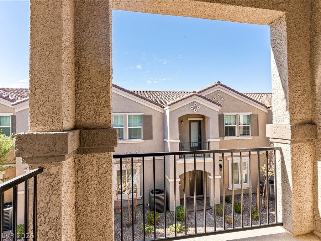 671 Foam Flower Lane, Henderson, NV 89015 Stucco pillars and metal railings frame the view from this elevated concrete balcony.