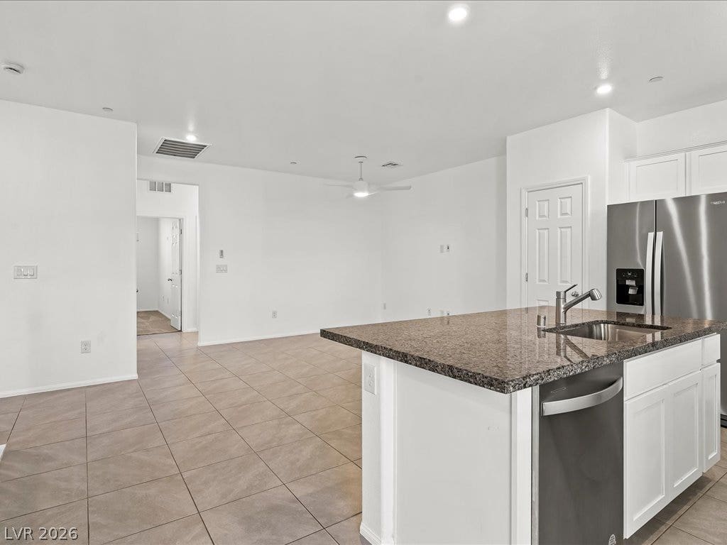 671 Foam Flower Lane, Henderson, NV 89015 Gleaming tile floors flow seamlessly from the kitchen island into an airy open living space.
