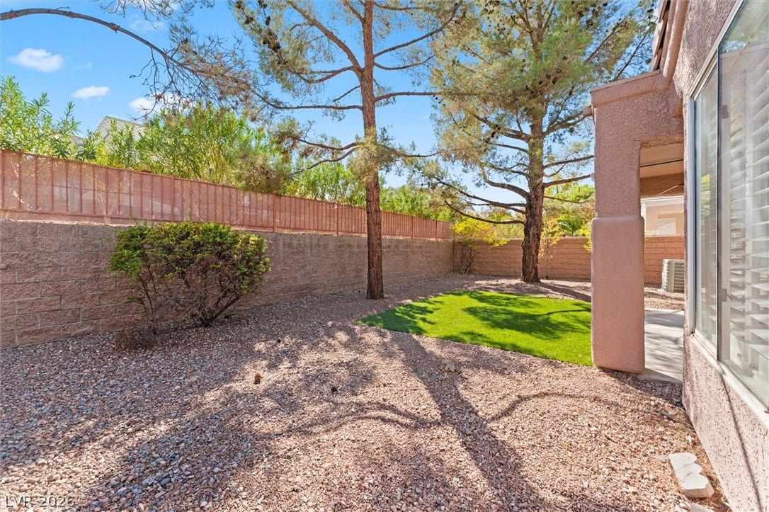 2163 Chapman Ranch Drive, Henderson, NV 89012 Mature trees shade a low-maintenance backyard enclosed by block wall fencing.