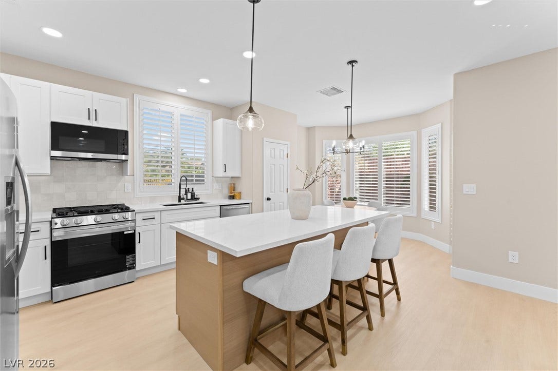 2163 Chapman Ranch Drive, Henderson, NV 89012 Smooth stone countertops and wood flooring anchor this modern open culinary space.