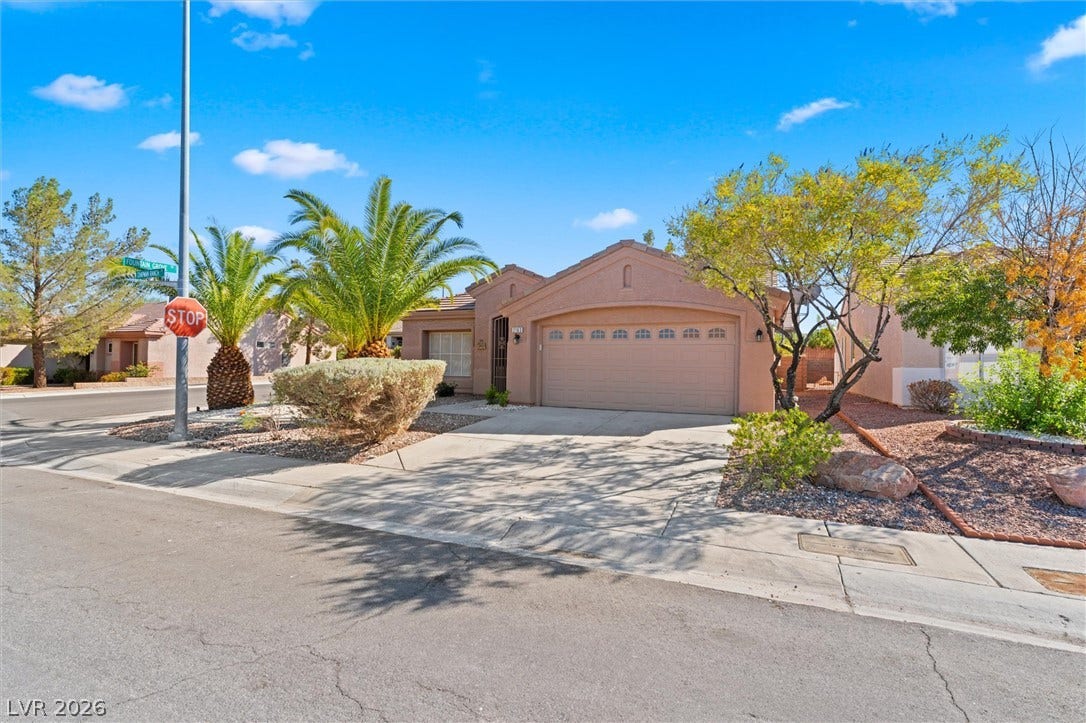 2163 Chapman Ranch Drive, Henderson, NV 89012 A spacious driveway leads to a prominent double garage beneath classic tile roofing.