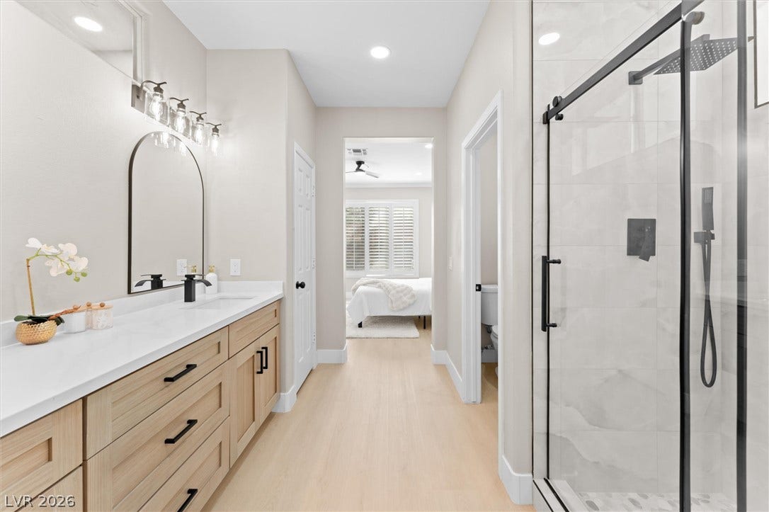 2163 Chapman Ranch Drive, Henderson, NV 89012 Smooth wood floors and a glass-enclosed walk-in shower elevate this modern bathroom design.