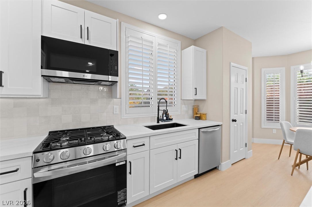 2163 Chapman Ranch Drive, Henderson, NV 89012 Crisp white cabinetry paired with modern stainless steel appliances creates an inviting culinary space.