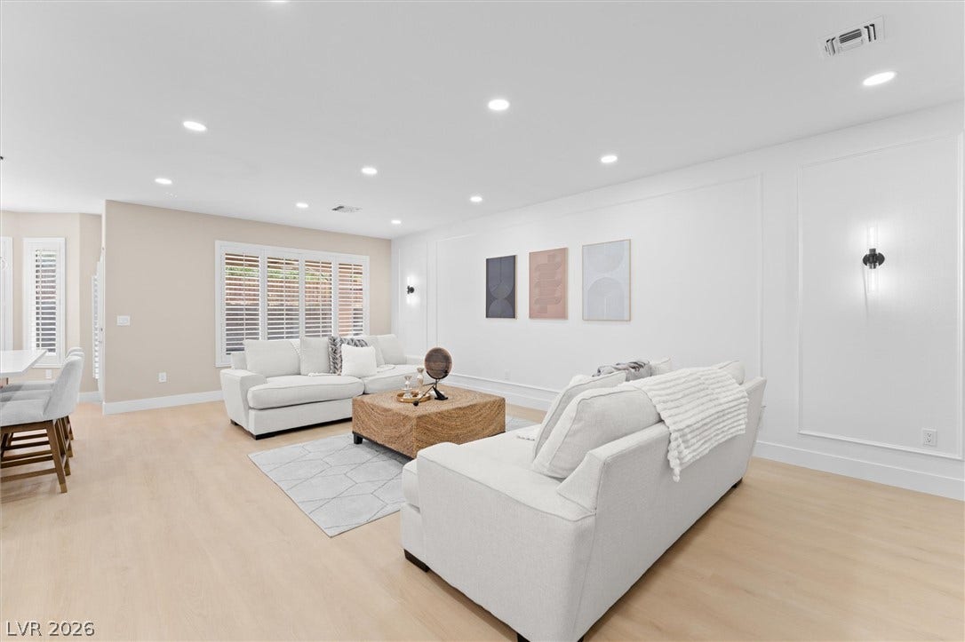 2163 Chapman Ranch Drive, Henderson, NV 89012 Gleaming hardwood floors and classic wall paneling elevate this airy, light-filled gathering space.