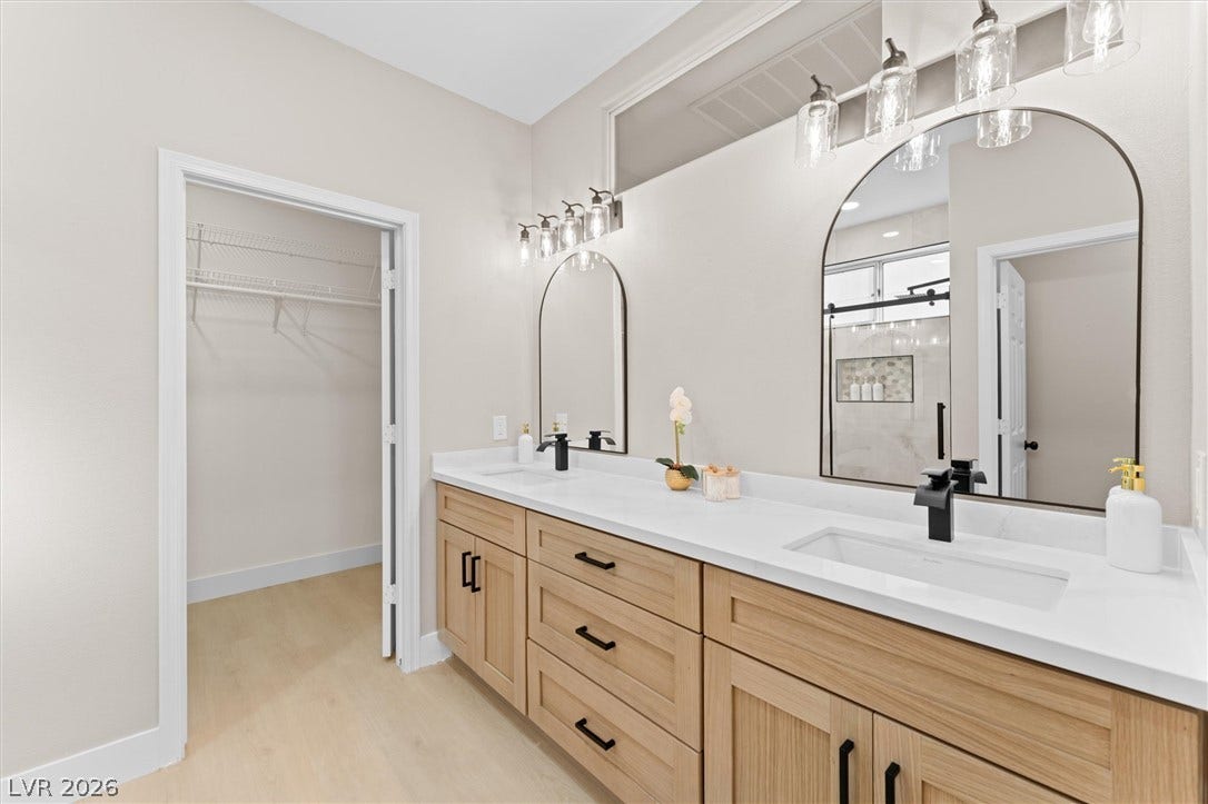 2163 Chapman Ranch Drive, Henderson, NV 89012 An elegant double vanity pairs with wood-look flooring and adjacent closet storage.