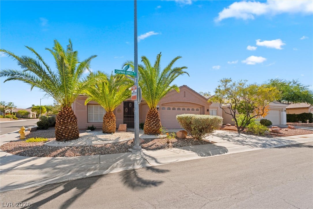 2163 Chapman Ranch Drive, Henderson, NV 89012 Lush palm trees and classic desert landscaping frame this welcoming corner lot single-family home.
