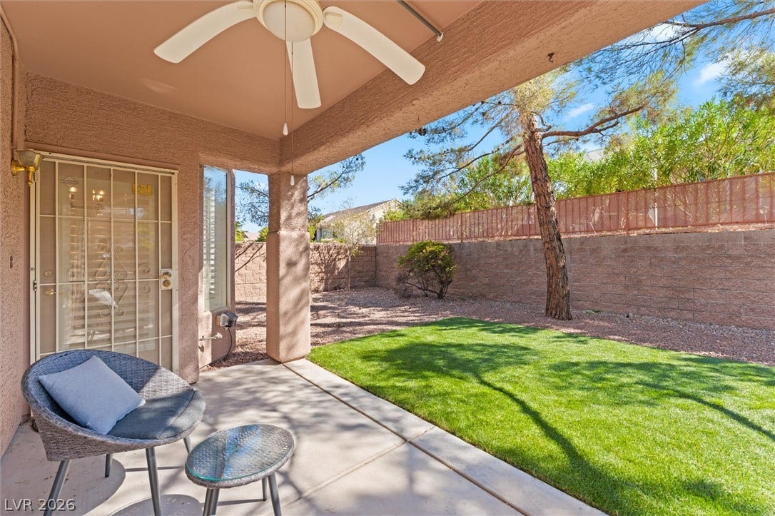 2163 Chapman Ranch Drive, Henderson, NV 89012 Covered concrete patio overlooks a fenced backyard with lawn space and mature trees.