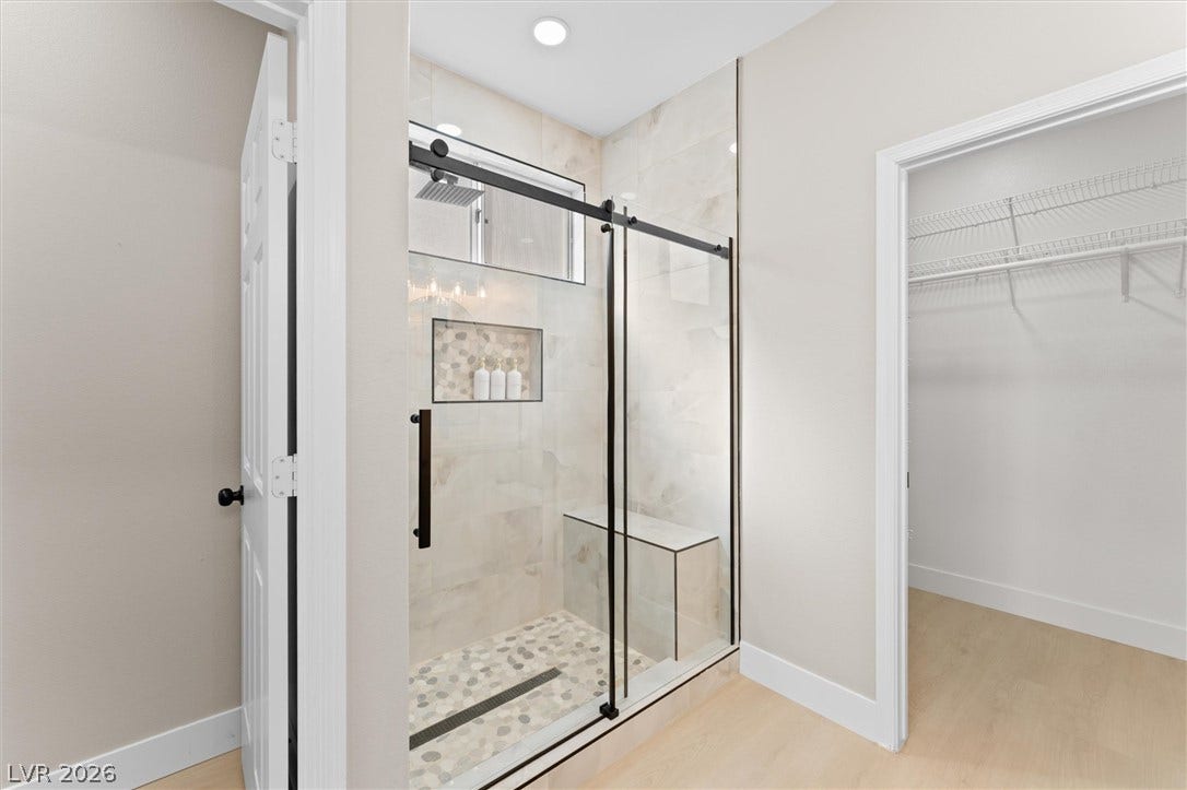 2163 Chapman Ranch Drive, Henderson, NV 89012 Clean lines and a tiled walk-in shower define this modern, light-filled bathroom space.