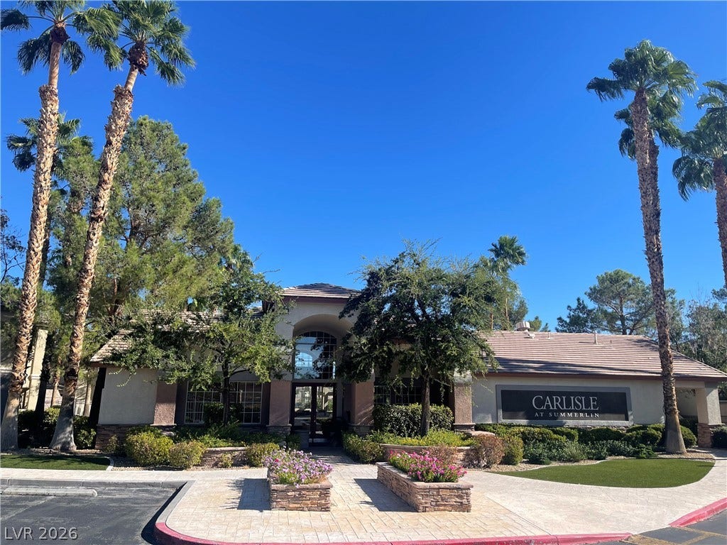 1617 Queen Victoria Street, #201, Las Vegas, NV 89144 Palm trees frame the arched entryway of this desert community clubhouse under clear skies.