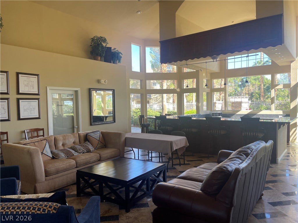 1617 Queen Victoria Street, #201, Las Vegas, NV 89144 Soaring ceilings and walls of windows frame the tile-floored community area and wet bar.