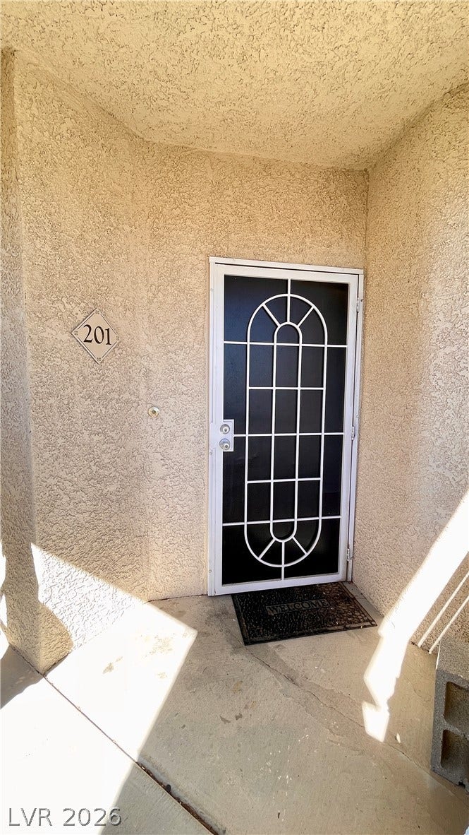 1617 Queen Victoria Street, #201, Las Vegas, NV 89144 A private covered entryway features durable stucco walls and a secure decorative storm door.