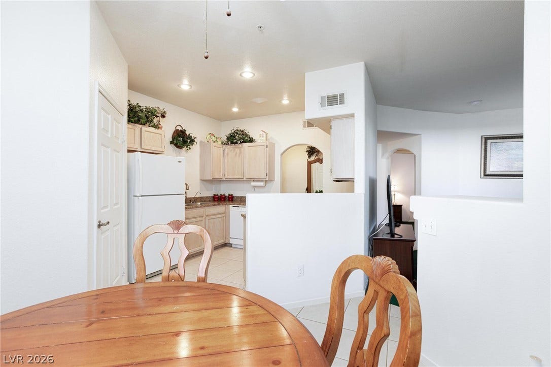 Recessed lighting and tile floors flow through an open layout connecting the kitchen and dining space.