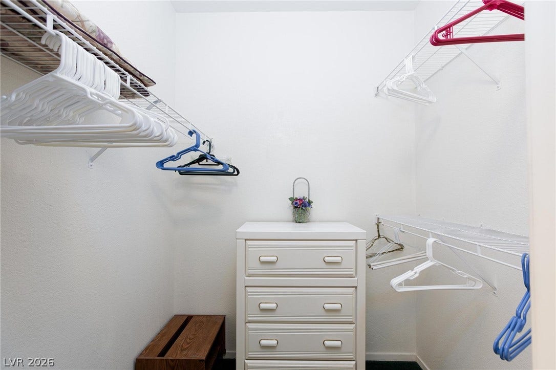 Ample wire shelving and hanging rods maximize storage efficiency in this walk-in closet.