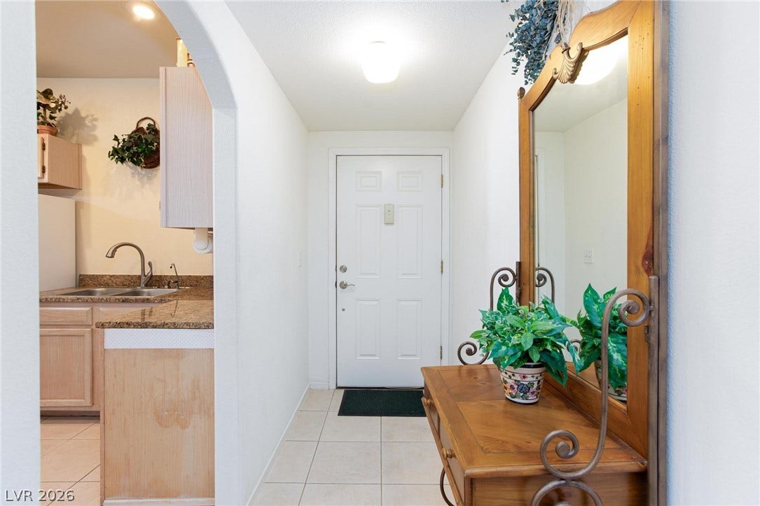 A welcoming arched entryway leads past the kitchen and features tiled flooring.