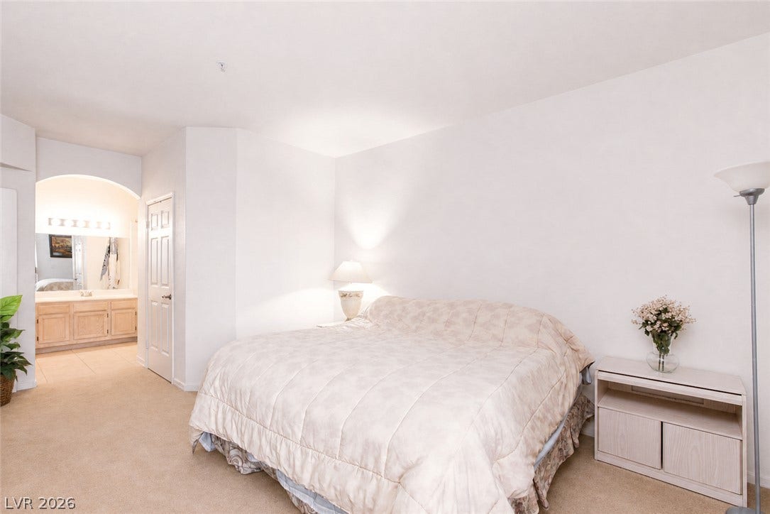 An arched opening connects this bedroom suite directly to the adjoining vanity area.
