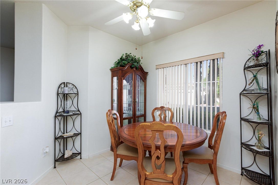 Tiled flooring and natural light from a large window create a welcoming dining space.