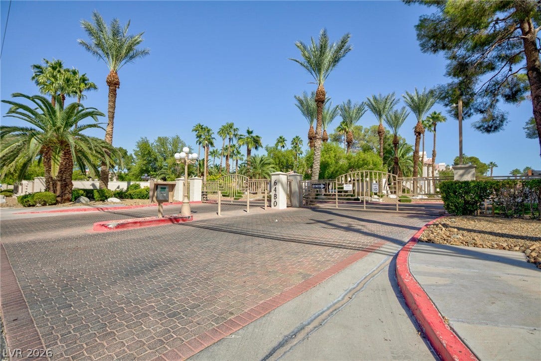 A secure gated entrance leads into this beautifully landscaped community lined with palm trees.