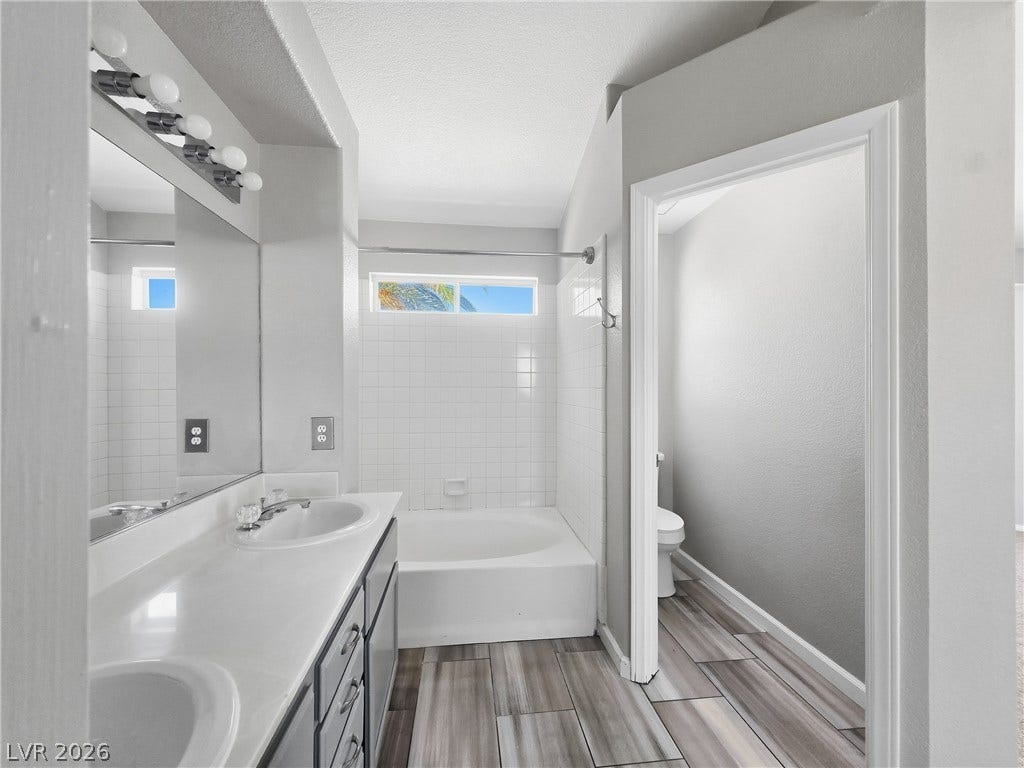 A spacious double vanity and a built-in soaking tub define this modern bathroom layout.
