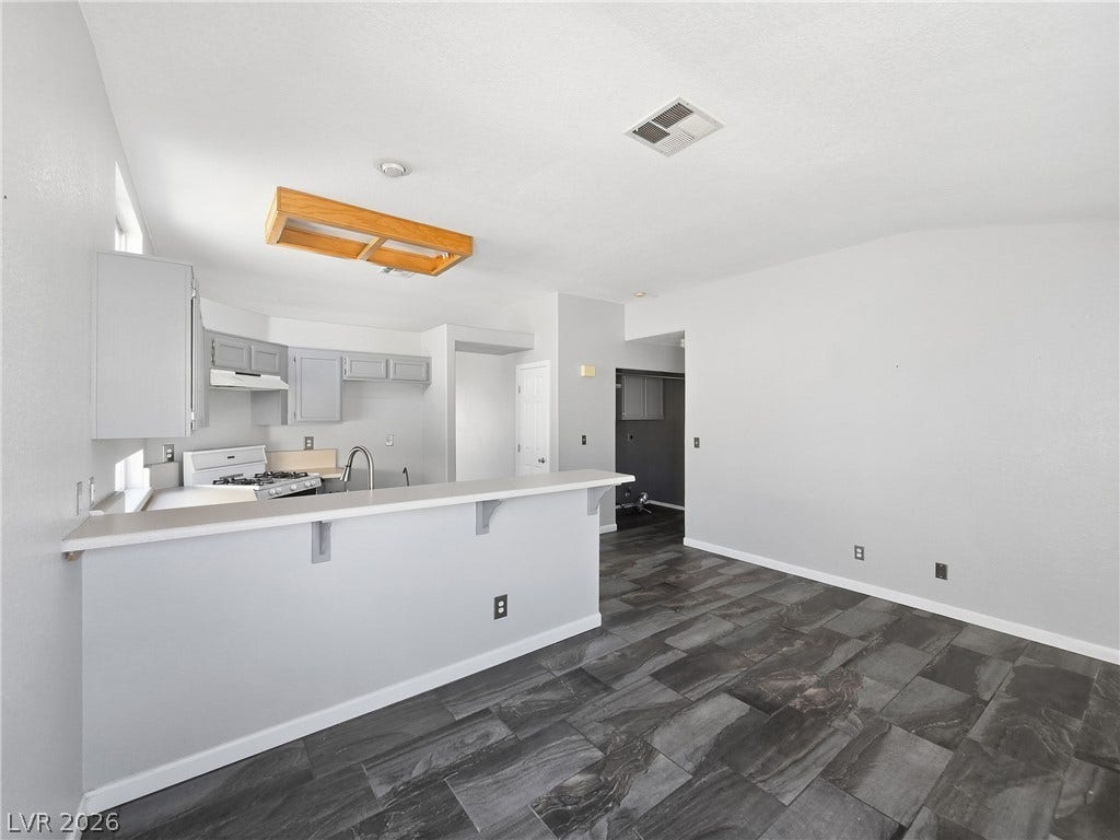 An open floorplan seamlessly connects the kitchen bar to a spacious dining area.