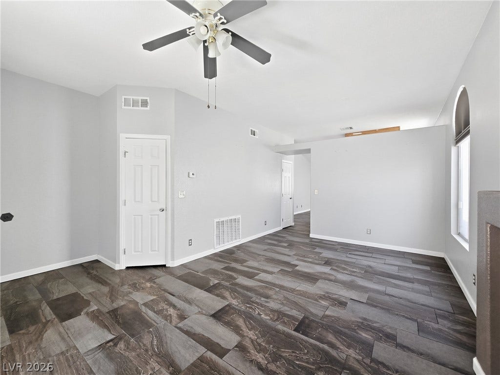 Striking dark tile flooring anchors this open living space with high vaulted ceilings.