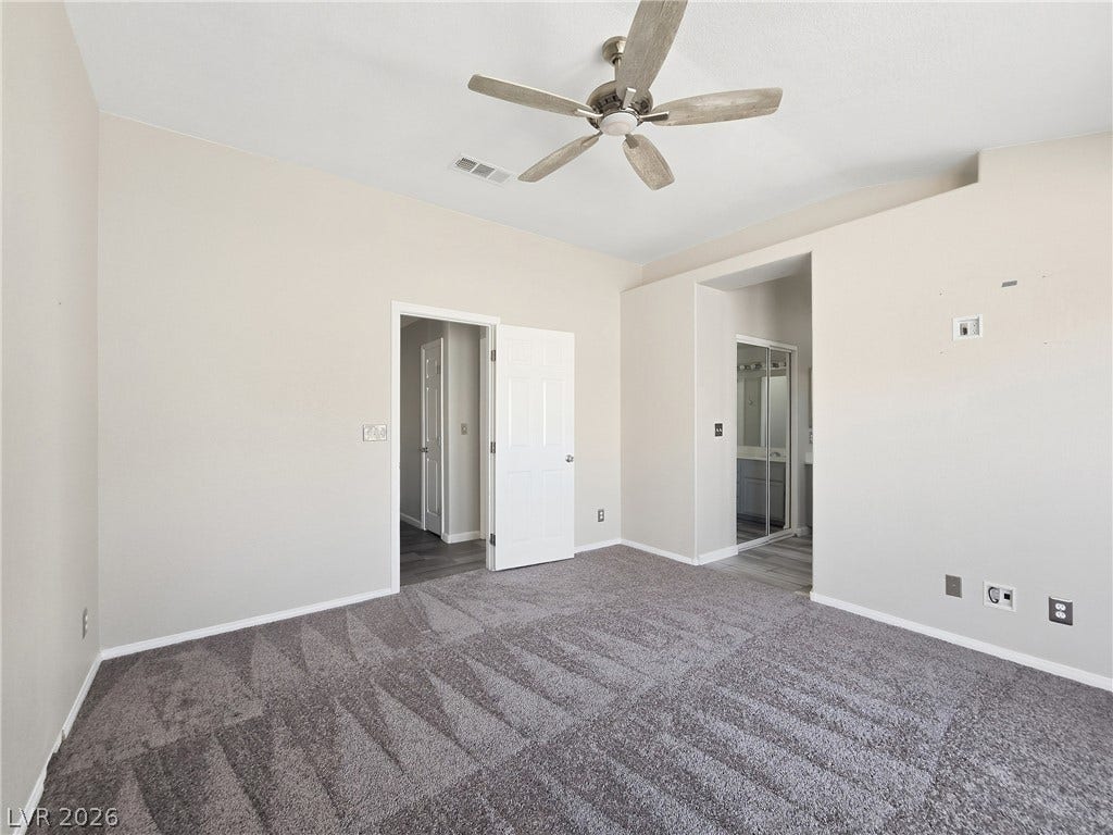 High ceilings and clean lines define this carpeted bedroom suite.