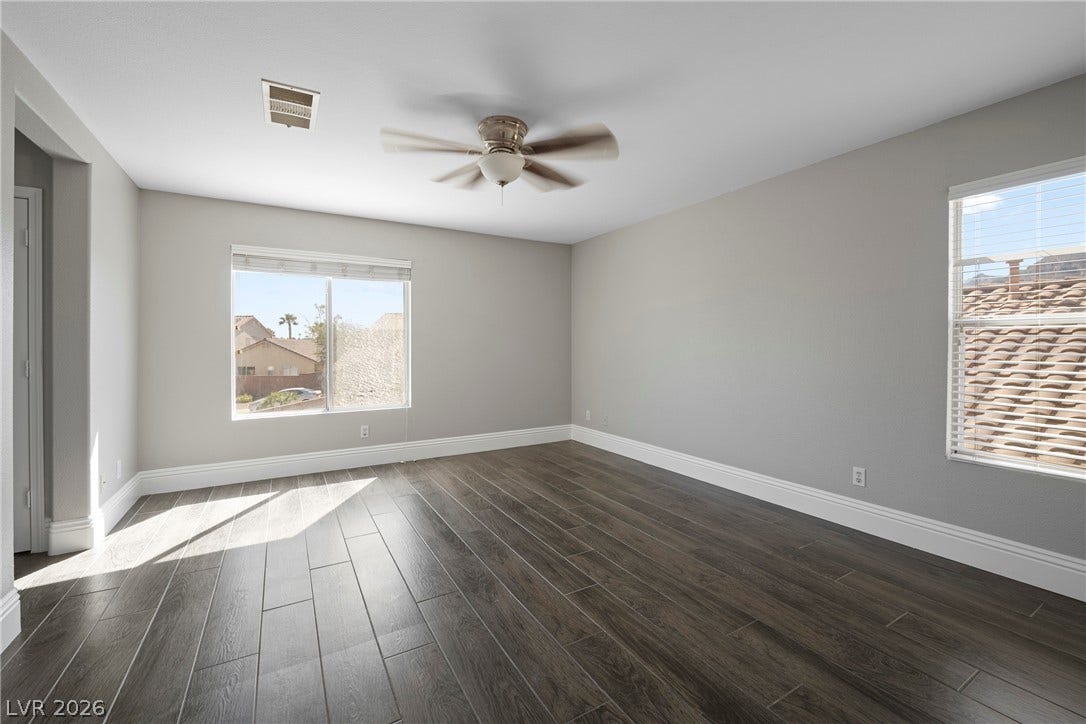 Gleaming wood-look floors complement clean walls and generous natural light in this versatile space.