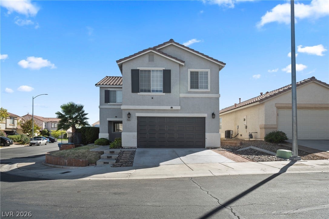An inviting stucco facade presents clean lines under a classic tile roof.
